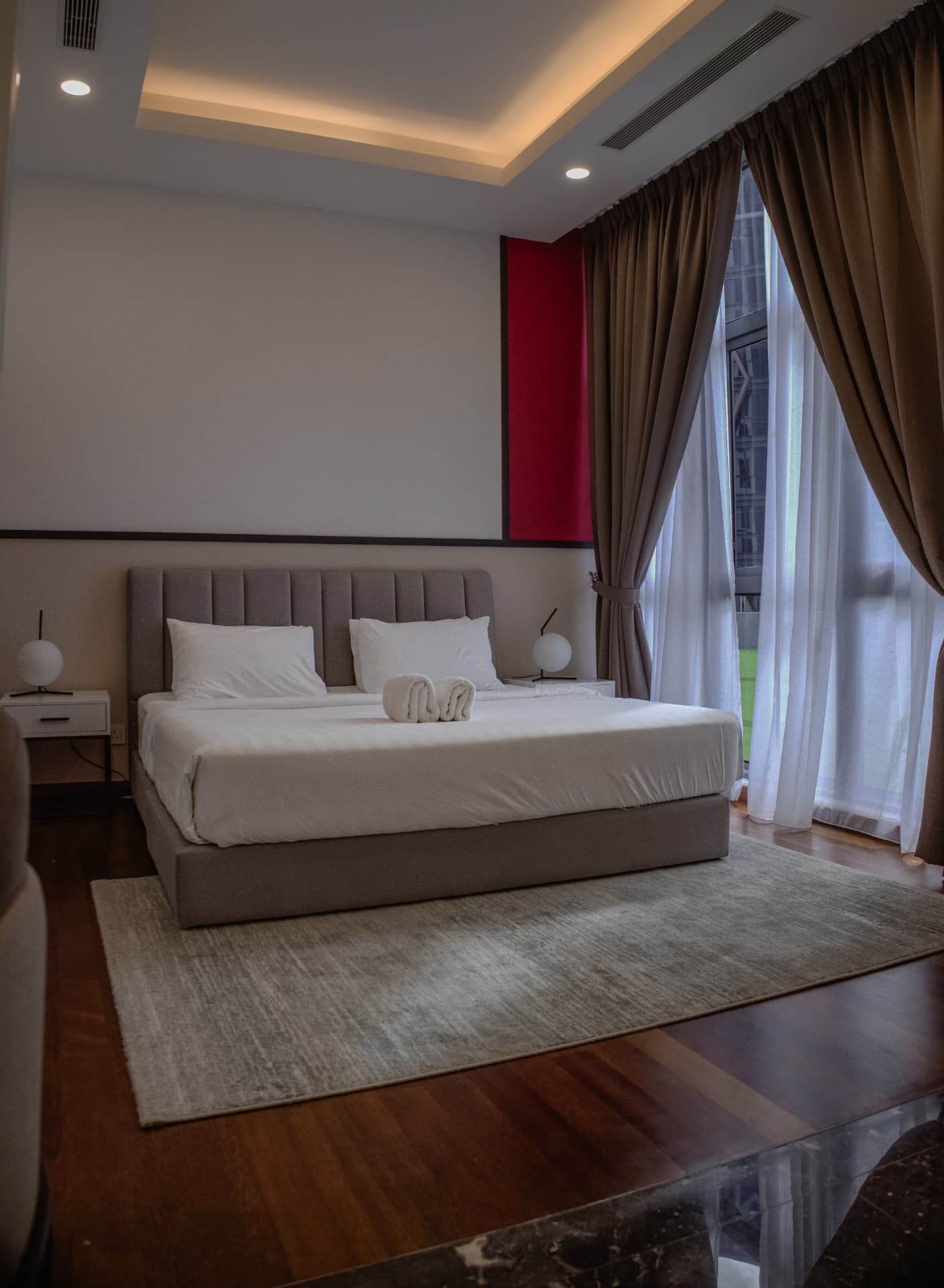 Luxury bedroom with king bed, cove lighting and floor-to-ceiling windows