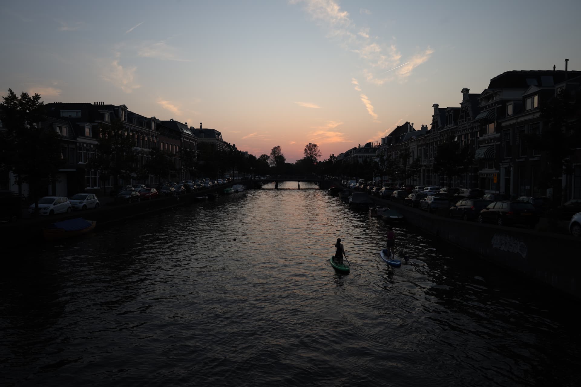 Paddleboarders on an Amsterdam canal at sunset