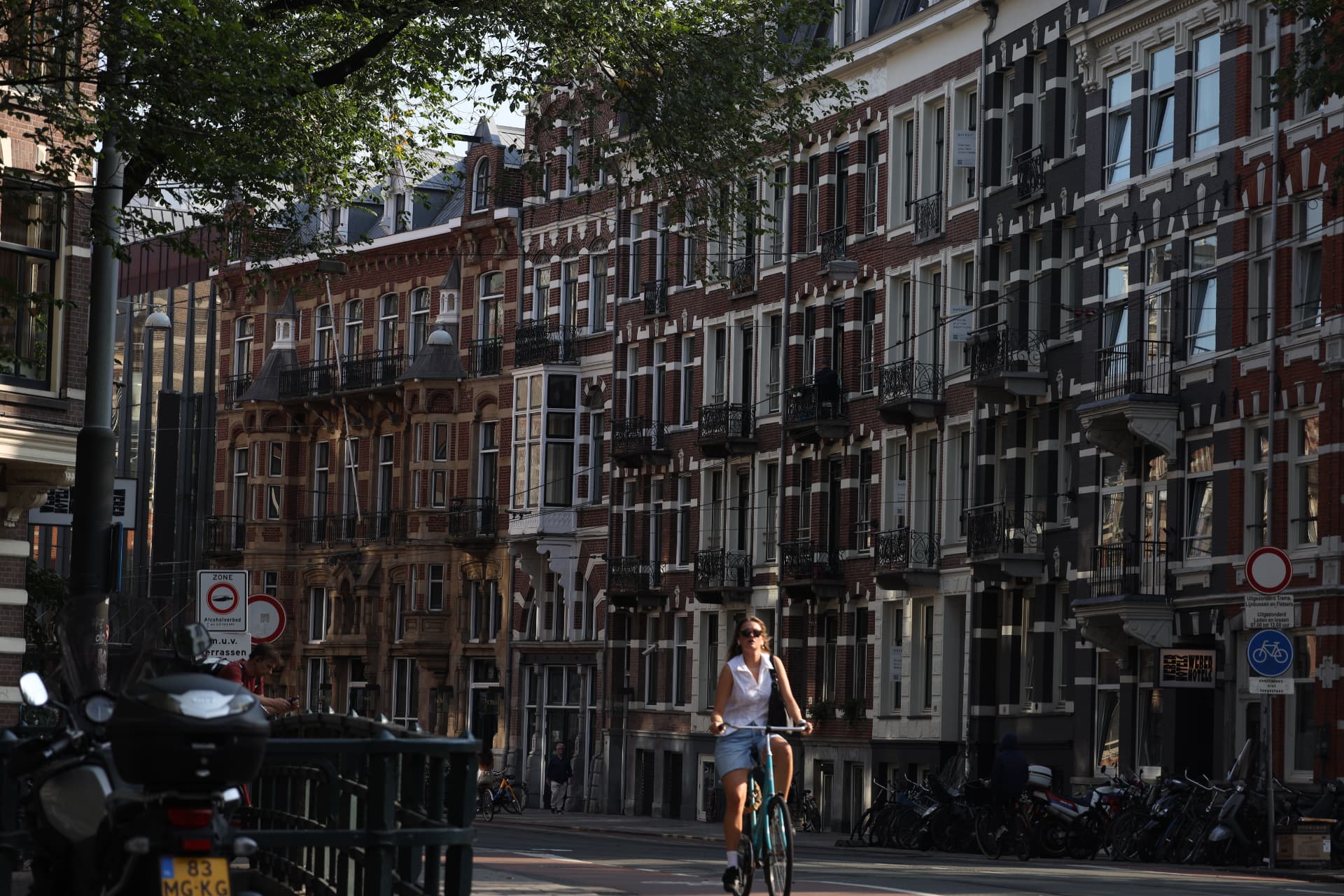 Cyclist on an Amsterdam street lined with canal houses