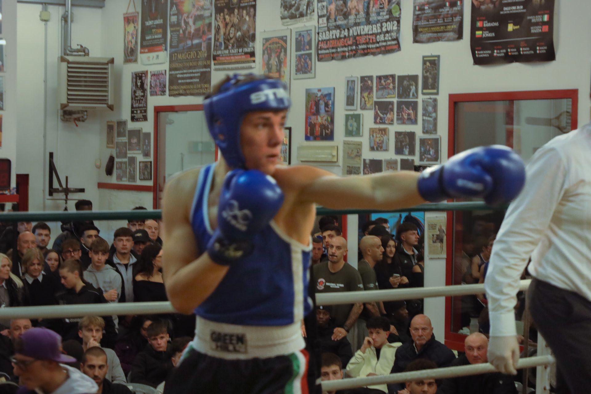 Boxer in blue extending a jab during an amateur bout