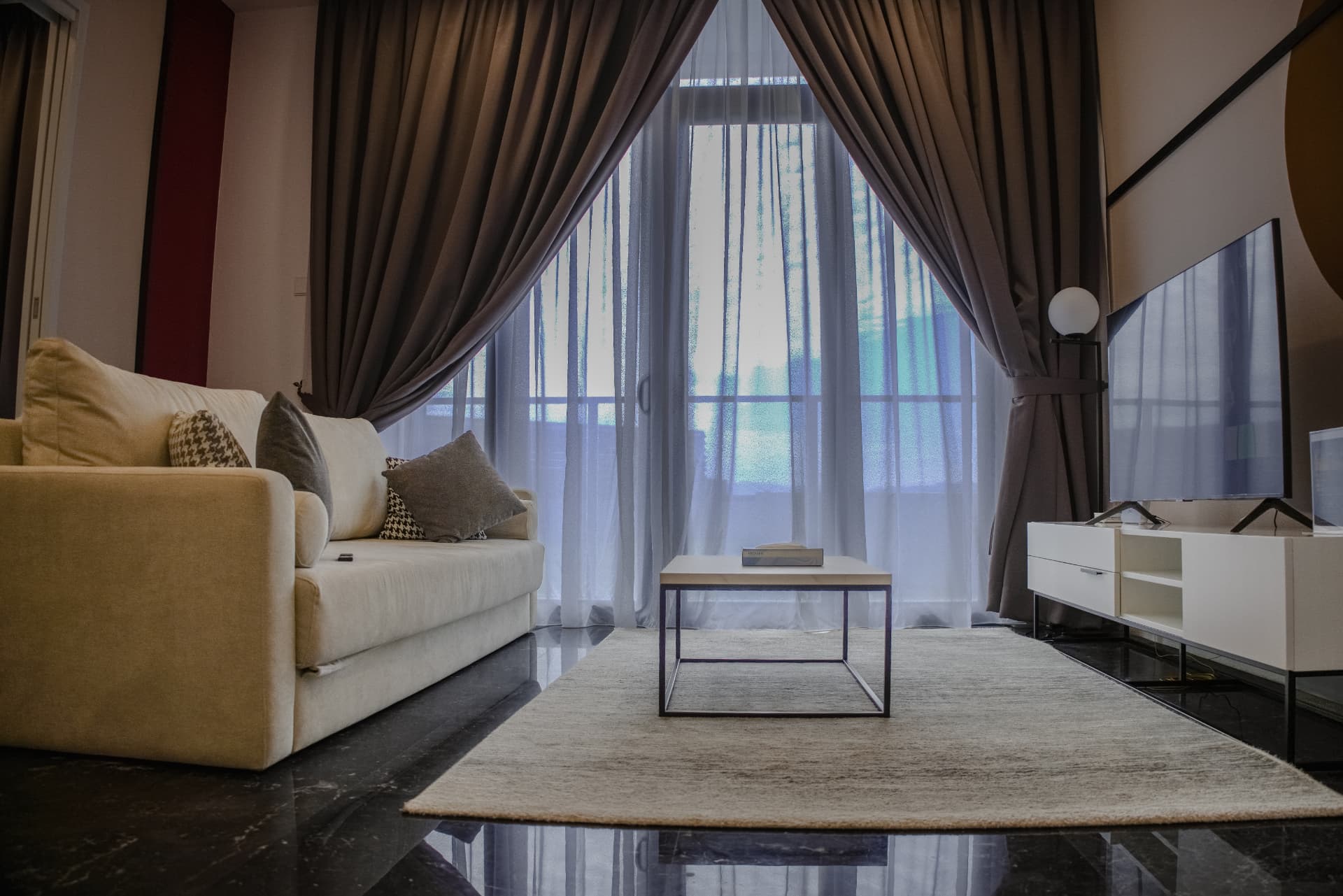Modern apartment living room with sheer curtains and city balcony