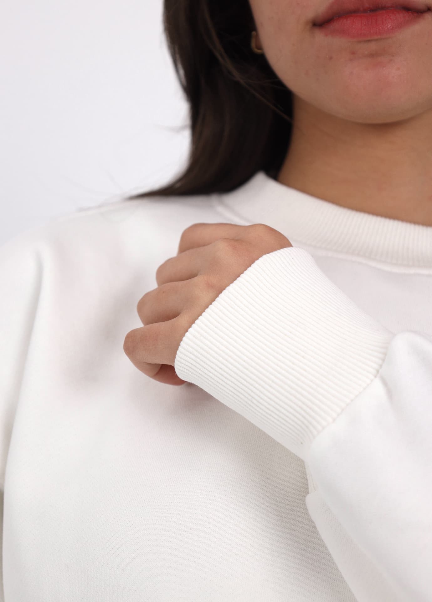 Detail shot of a white sweatshirt cuff and ribbed collar