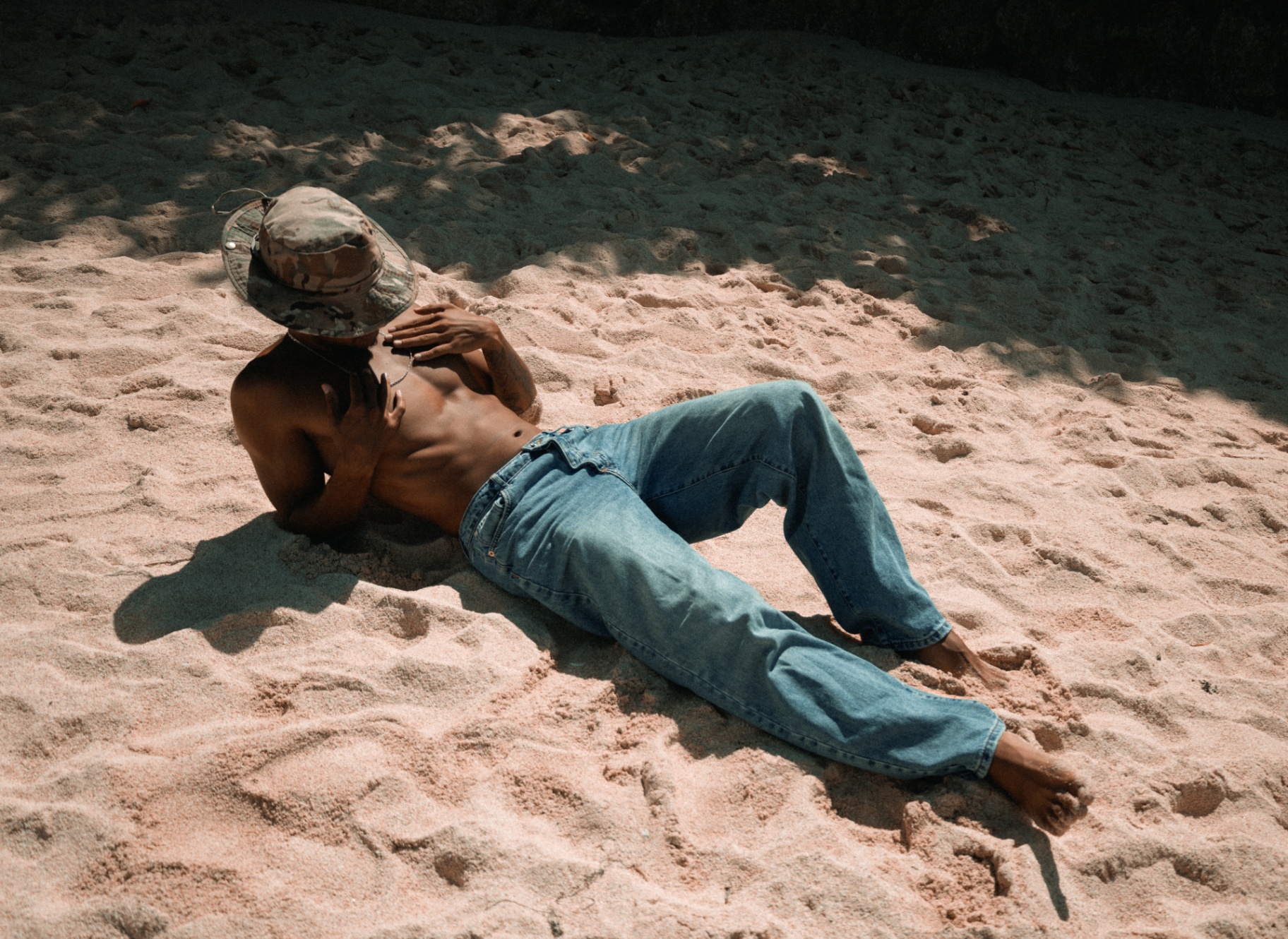 Editorial portrait of a man resting on the sand in Bali