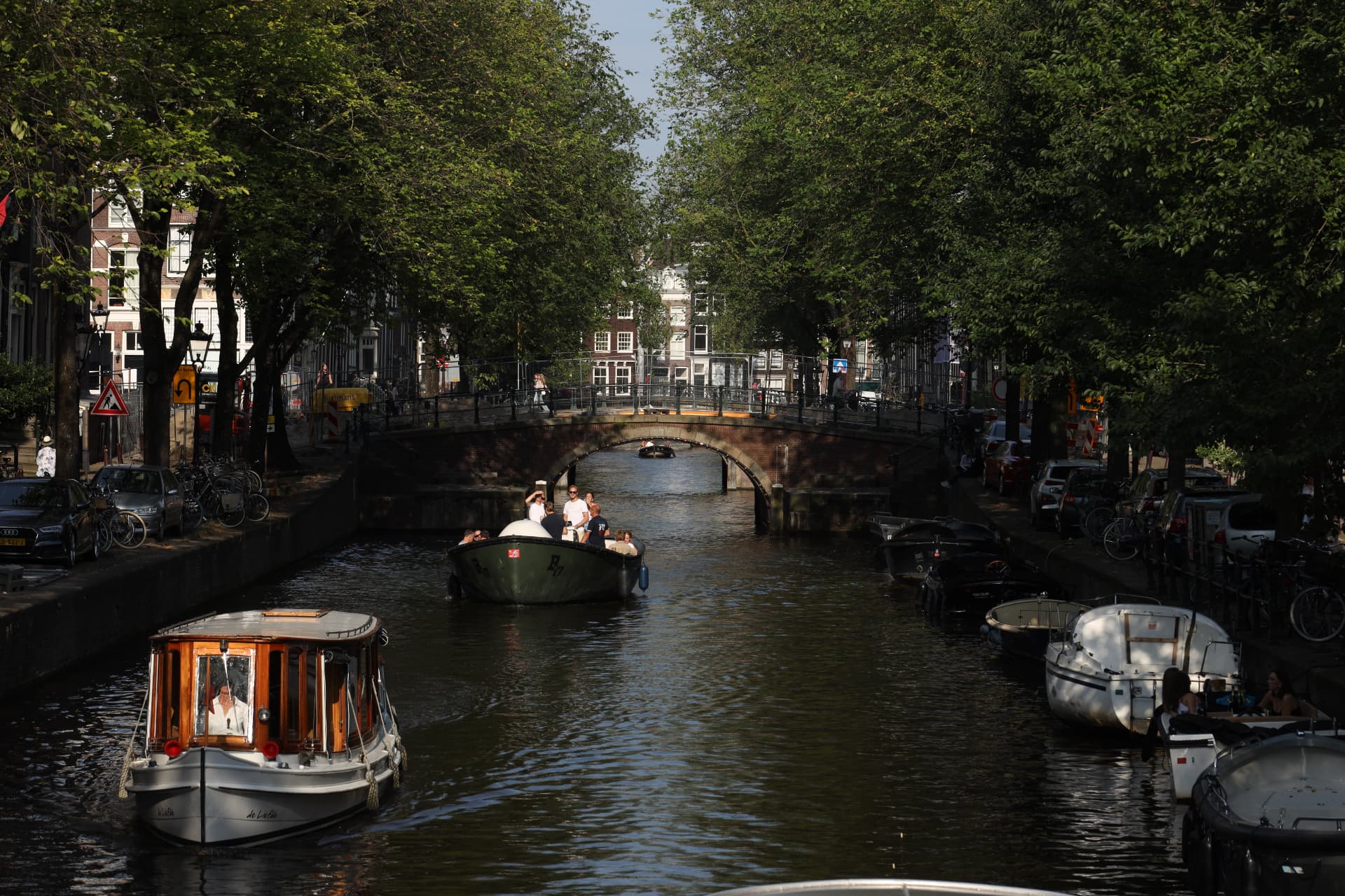 Boats passing under a canal bridge in Amsterdam